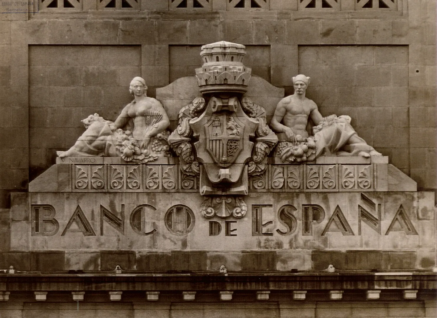 Sucursal de Barcelona. Remate escultórico de la fachada, obra de Vicente Navarro Romero. Escudo de España flanqueado por las alegorías de Minerva y Mercurio (vía Layetana, 32-34, sede entre 1932 y 1955, obra de los arquitectos José Yárnoz Larrosa y Luis Menéndez Pidal). 1932. Fotógrafo: Andreu Puig Farran. Positivo. Plata en gelatina. N.º inv. 4360.