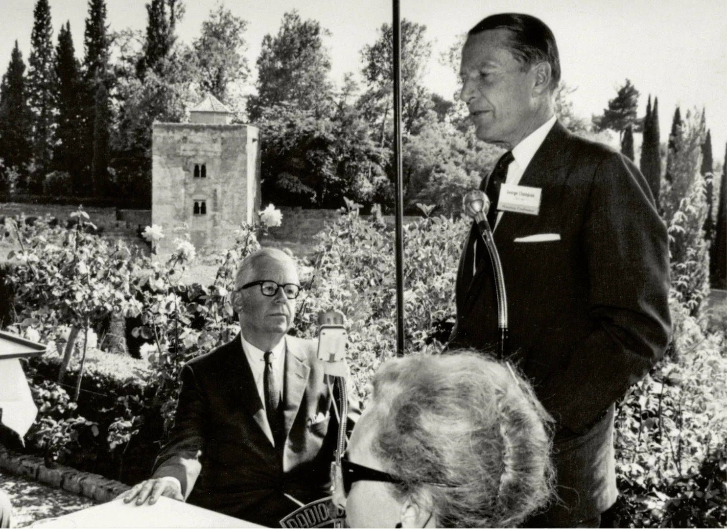 XIII Conferencia Monetaria de la American Bankers Association, celebrada en España entre el 23 y el 27 de mayo de 1966. Acto de clausura en los jardines del Generalife. Discurso de George Champion; sentado, Henry Hammill Fowler. 27 de mayo de 1966. Fotógrafo: Manuel Torres Molina. Positivo. Plata en gelatina. N.º inv. 4709.