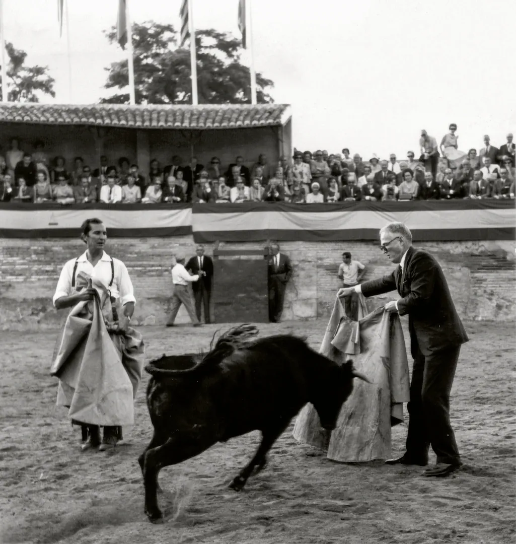 XIII Conferencia Monetaria de la American Bankers Association, celebrada en España entre el 23 y el 27 de mayo de 1966. Fiesta campera ofrecida por la banca española en la finca Castillo de Higares, en Mocejón (Toledo). James Dewey Daane, miembro del Consejo de Gobernadores de la Reserva Federal de Estados Unidos, toreando una vaquilla en presencia del torero Luis Miguel Dominguín. 23 de mayo de 1966. Fotógrafo: Manuel Aumente Menéndez. Positivo. Plata en gelatina. N.º inv. 5486.