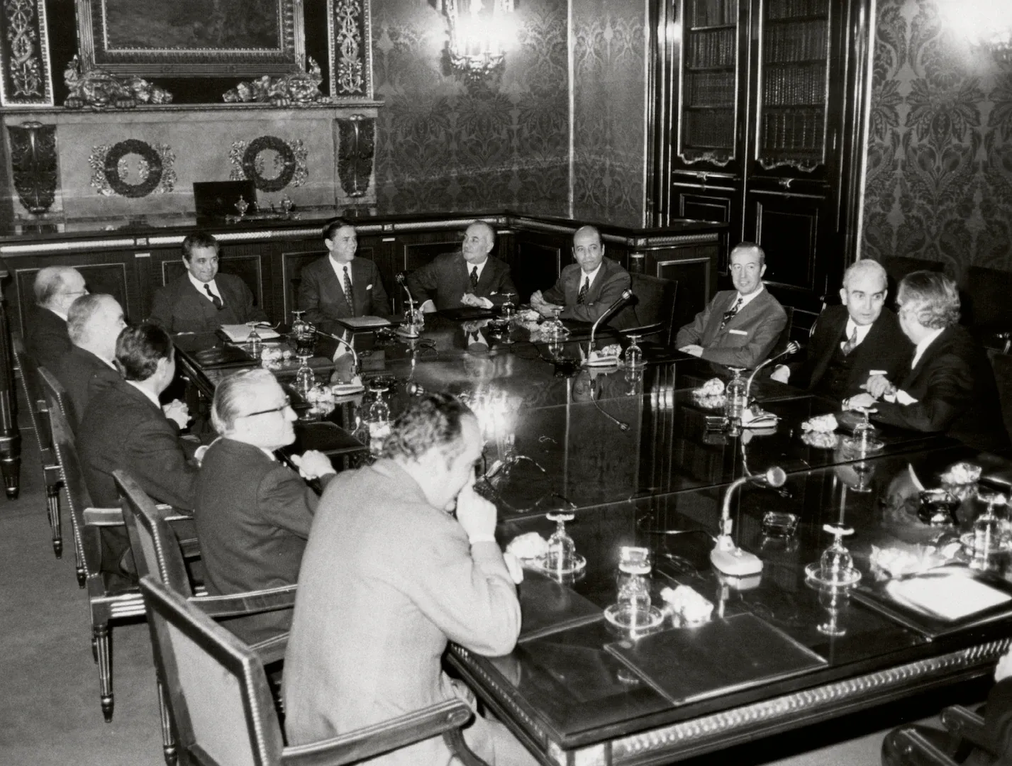 Reunión del ministro de Hacienda y del gobernador del Banco de España con la mesa de la Cámara Oficial de Comercio, Industria y Navegación de Barcelona en la casa Lonja del Mar. Asisten, entre otros, Alberto Monreal Luque, ministro de Hacienda; Luis Coronel de Palma, gobernador del Banco de España; Francisco Fernández Ordóñez, director general del Ministerio de Hacienda; Andrés Ribera Rovira, presidente de la Cámara; Antonio Suqué Puig, presidente de la Junta de Obras del Puerto de Barcelona, y Carlos de Godó y Valls, procurador en Cortes. 23 de marzo de 1971. Fotógrafo: Carlos Pérez de Rozas. Positivo. Plata en gelatina. N.º inv. 5838