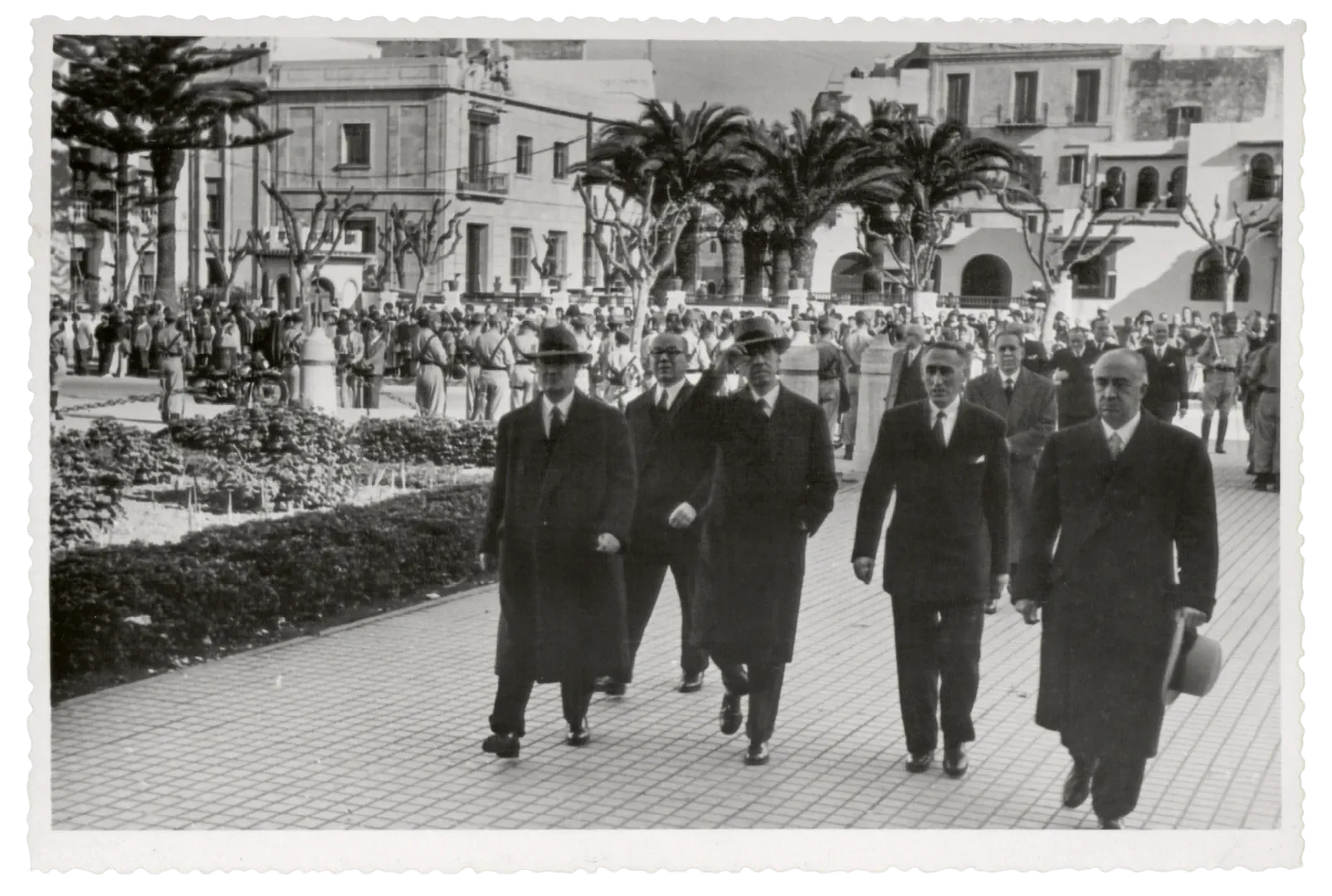 Agencia de Larache. Acto oficial de inauguración del nuevo edificio. Llegada del gobernador, Joaquín Benjumea Burín, acompañado del consejero Luis Olariaga, del secretario Alberto Alcocer y del director general Antonio Rodríguez y Morales de Setién (avenida del Generalísimo Franco, 10, actual avenida de Mohamed V, sede entre 1951 y 1960, obra del arquitecto Juan de Zavala Lafora). 6 de diciembre de 1951. Fotógrafo: Francisco García Cortés. Positivo. Plata en gelatina. N.º inv. 7810.