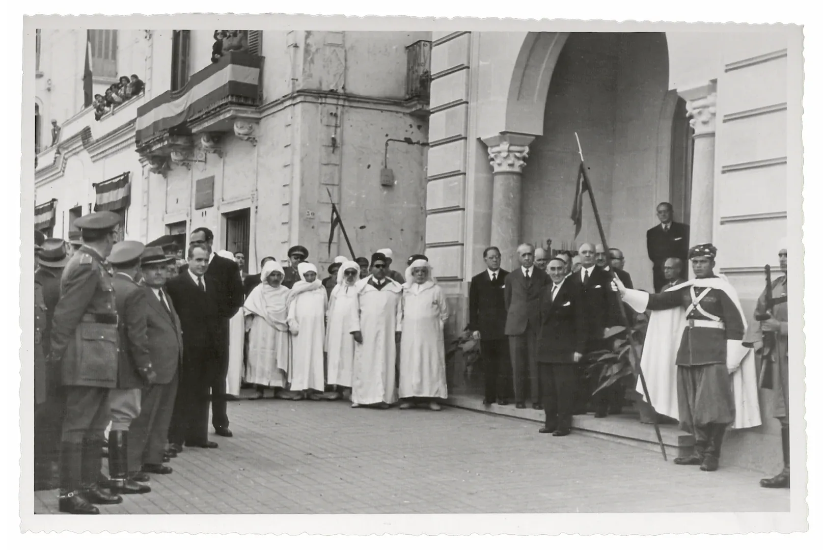 Agencia de Larache. Acto oficial de inauguración del nuevo edificio, con asistencia del alto comisario del Protectorado Español en Marruecos, teniente general Rafael García-Valiño Marcén, al que esperan el gobernador y los consejeros del Banco (avenida del Generalísimo Franco, 10, actual avenida de Mohamed V, sede entre 1951 y 1960, obra del arquitecto Juan de Zavala Lafora). 6 de diciembre de 1951. Fotógrafo: Francisco García Cortés. Positivo. Plata en gelatina. N.º inv. 7816.