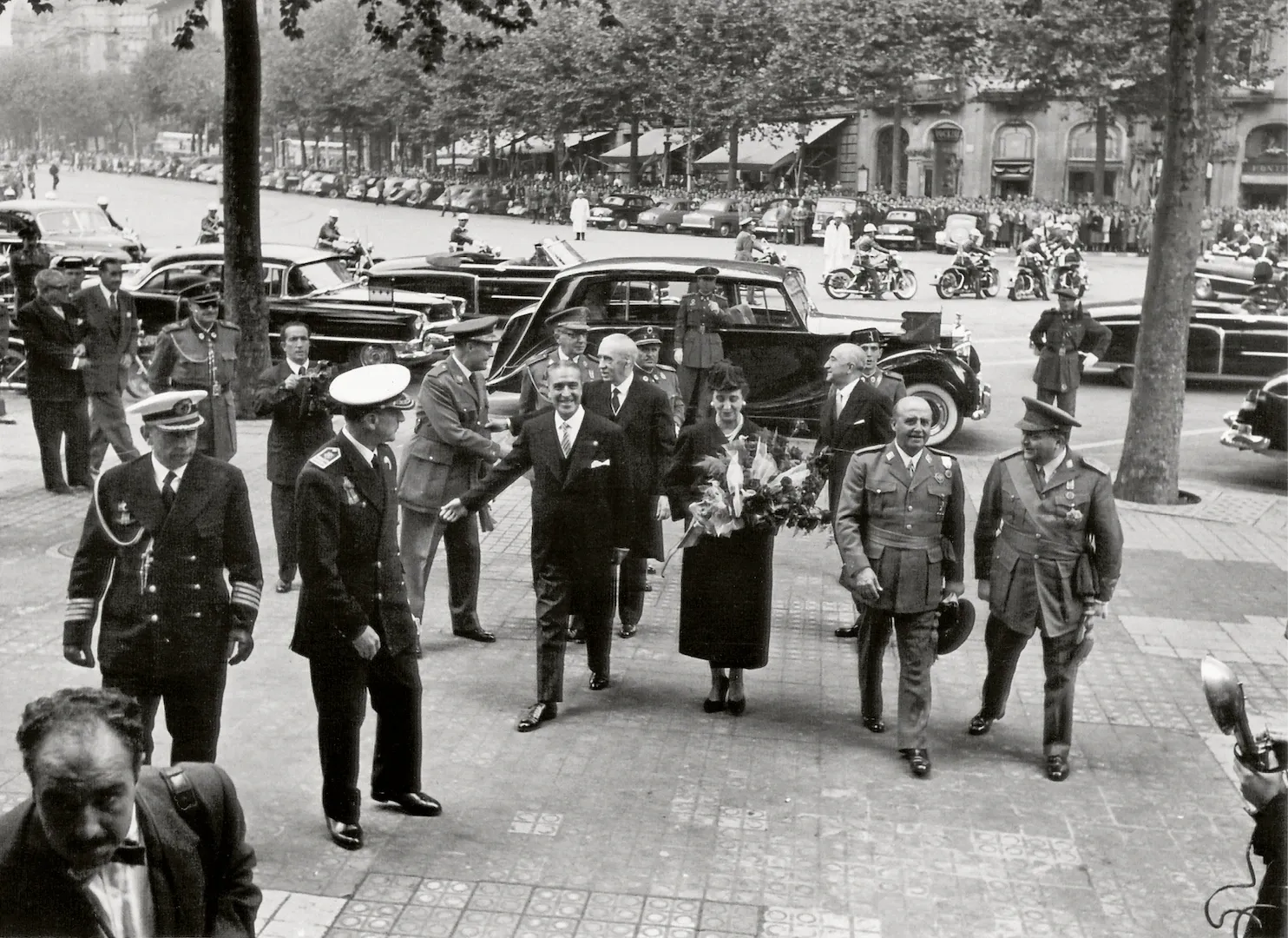 Sucursal de Barcelona. Acto oficial de inauguración del edificio. Llegada de Francisco Franco, jefe del Estado, acompañado de su esposa, Carmen Polo, del ministro de Hacienda, Francisco Gómez del Llano, y del gobernador del Banco de España, Joaquín Benjumea, entre otros (plaza de Cataluña, sede desde 1955, obra del arquitecto Juan de Zavala Lafora). 18 de octubre de 1955. Fotógrafo: Carlos Pérez de Rozas. Positivo. Plata en gelatina. N.º inv. 8015.