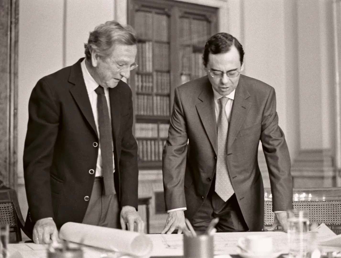 Madrid. El gobernador del Banco de España, Jaime Caruana, y el arquitecto Rafael Moneo, examinando los planos del edificio «cierre» del Banco de España, construido en la confluencia de las calles de Alcalá y Marqués de Cubas. Ca. 2004. Fotógrafa: Ana Muller. Negativo. Plata en gelatina. N.º inv. 9178.