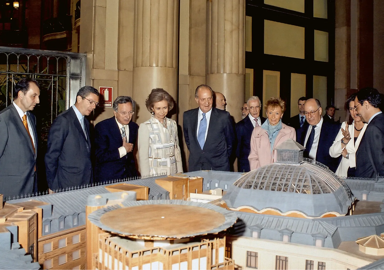 Inauguración de la última ampliación del edificio del Banco de España en la confluencia de las calles de Alcalá y Marqués de Cubas. El arquitecto Rafael Moneo mostrando a los reyes la maqueta del edificio. 2006. Fotógrafo: Borja Fotógrafos. Imagen digital.